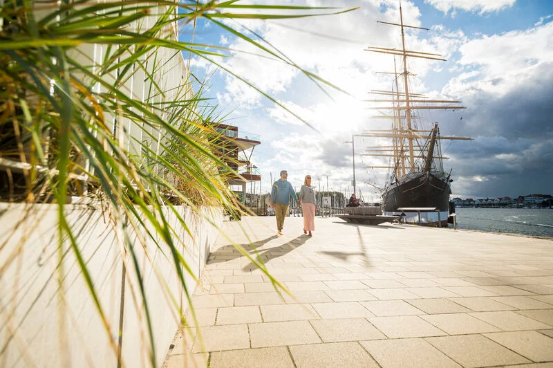 Ein Paar spaziert auf der Priwallpromenade in Travemünde