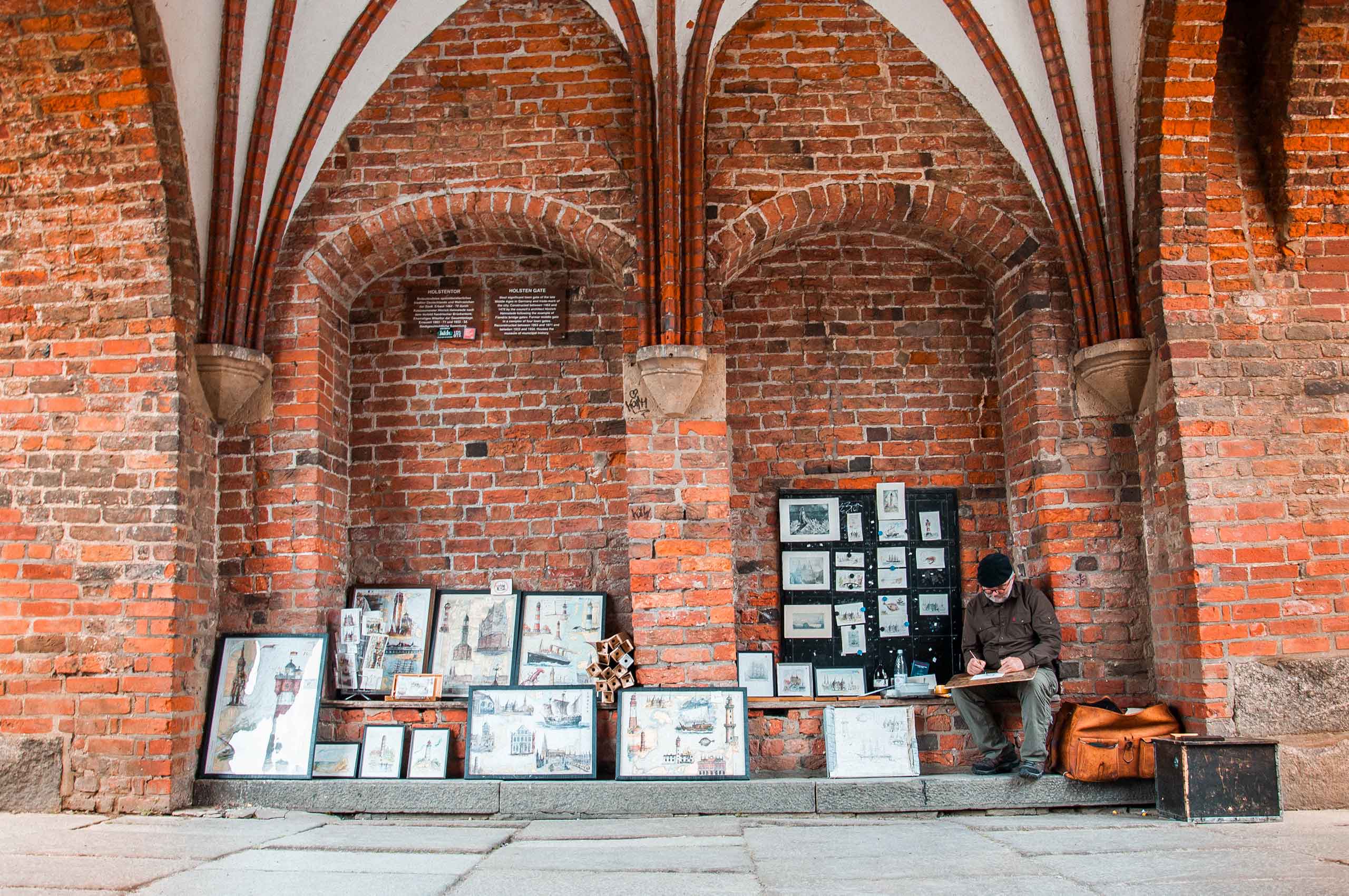 Künstler mit seinen Werken unter dem Holstentor