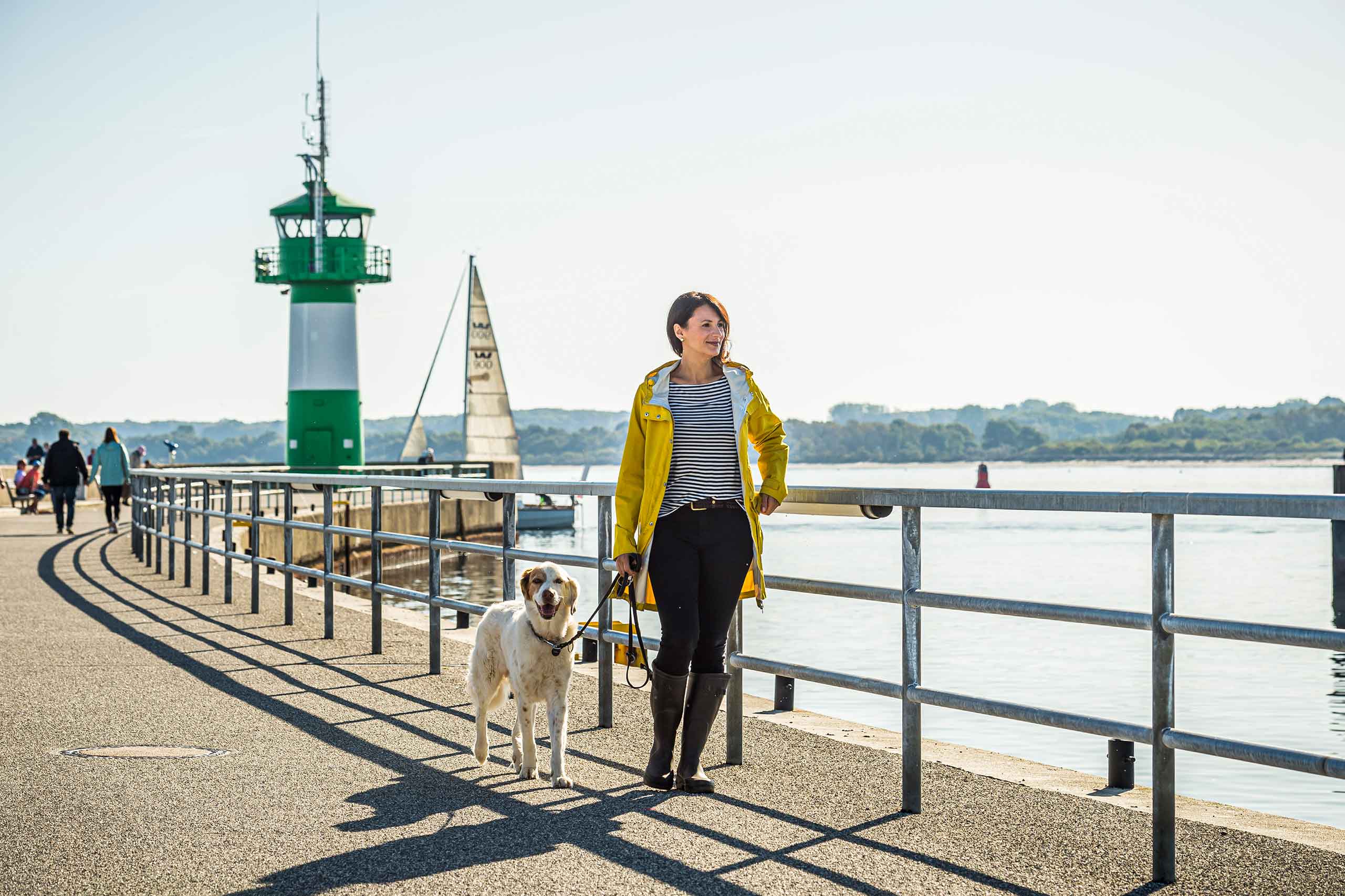 Frau geht mit Hund an der Nordermole spazieren